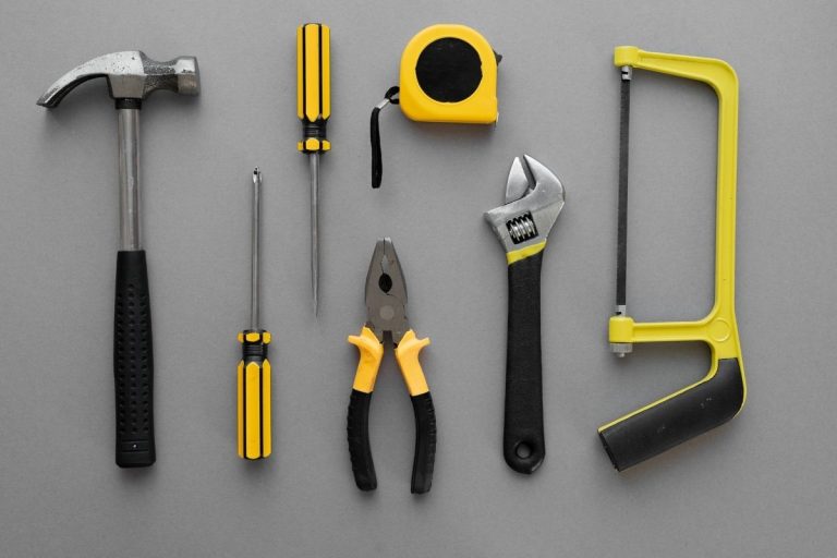 Various hand tools organized on a gray surface, illustrating a range of tools used for different tasks.